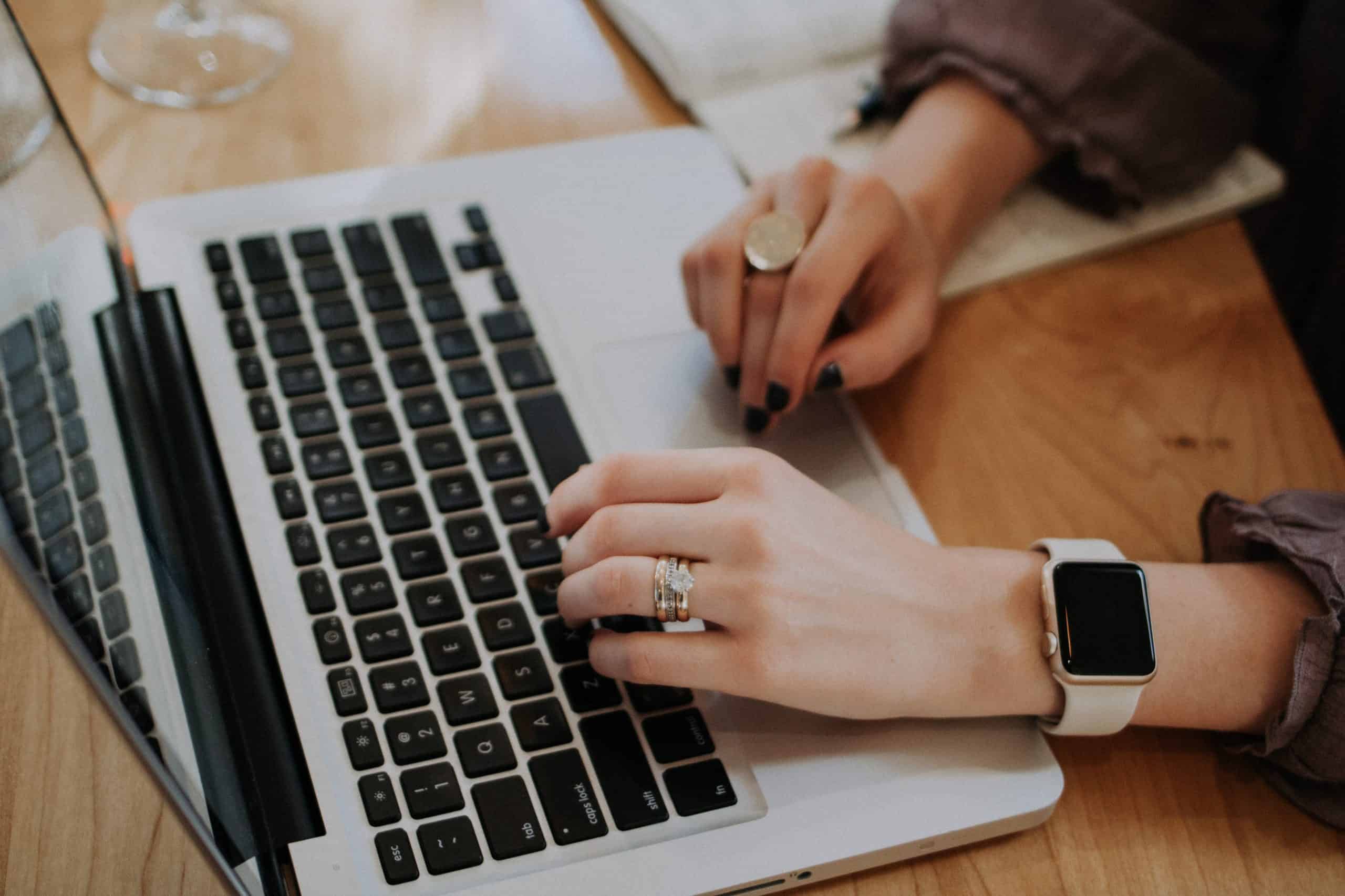 feminine hands typing on a laptop