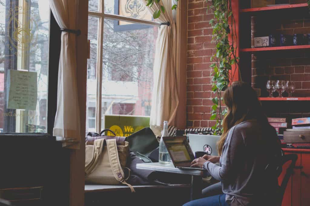 woman sitting at desk, typing on laptop in a red room