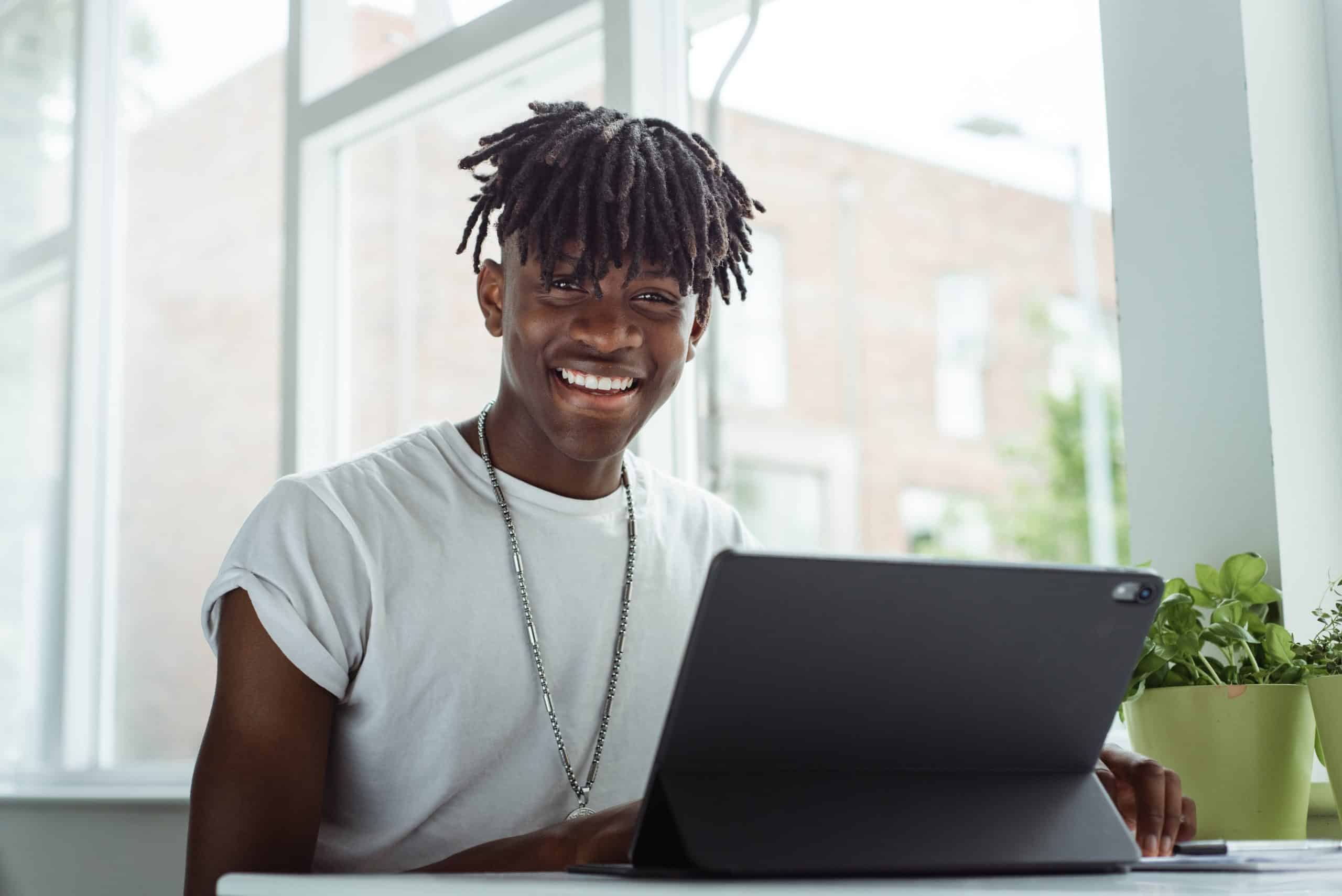 young male student learning a distance learning course through a laptop.