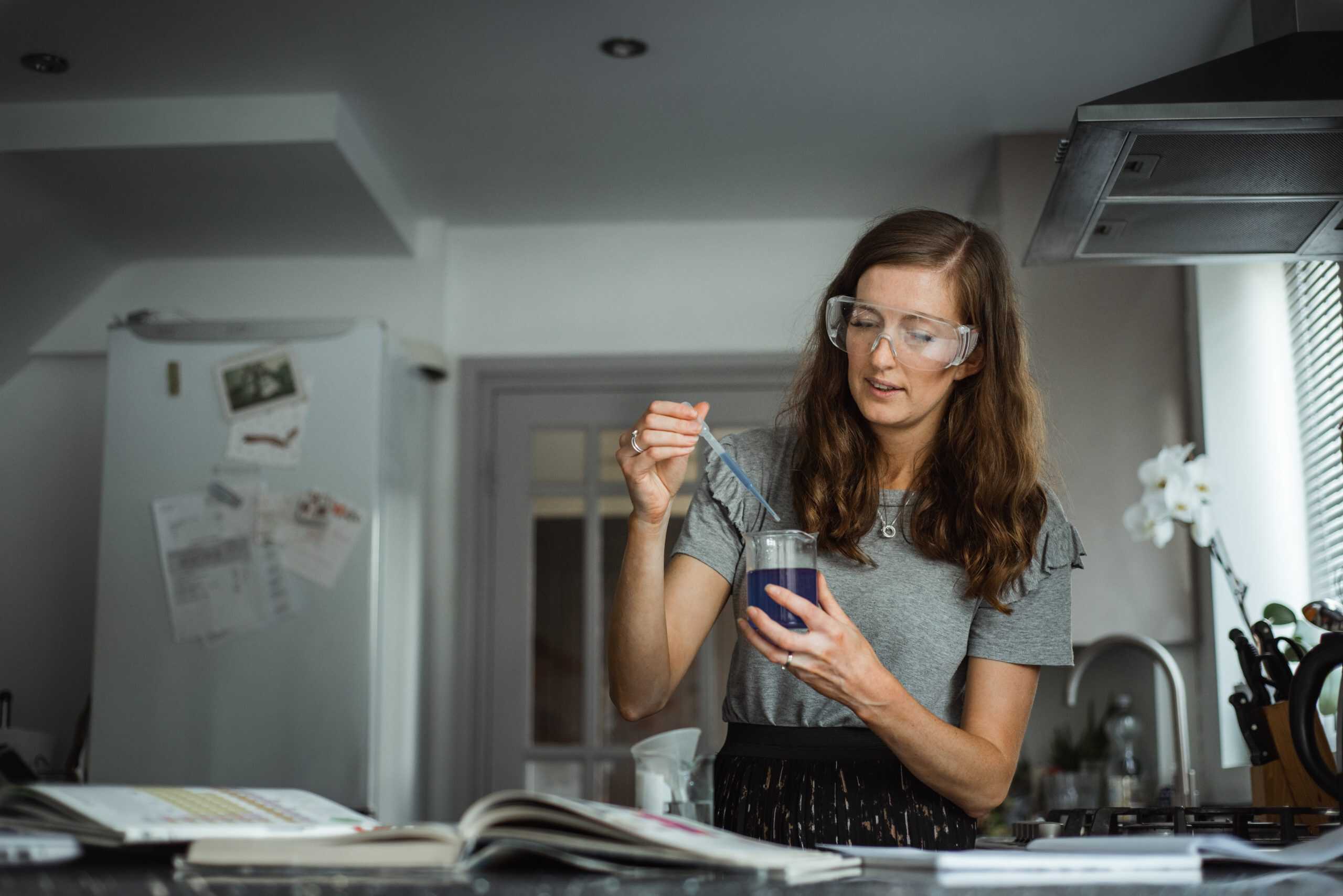 female doing a science experiment with NEC as a distance learning student