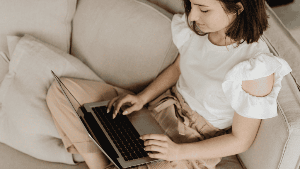 female sitting on sofa on laptop, looking at NEC's learning design