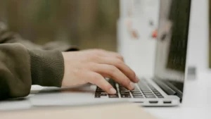 Typing on a laptop studying IGCSE Chemistry with the NEC