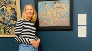 Jill standing in front of some paintings in a gallery