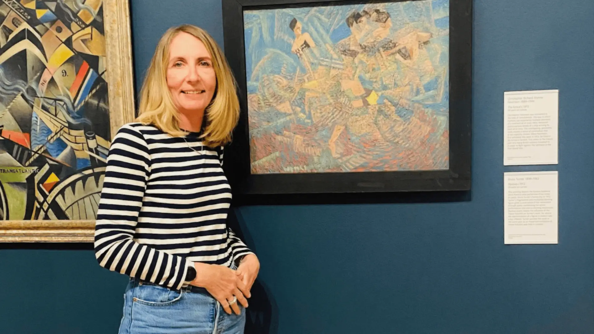 Jill standing in front of some paintings in a gallery