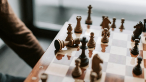 A close-up of a chessboard mid-game with a toppled king—symbolising deep thinking, strategic analysis, and the philosophical themes of logic, consequence, and decision-making. Symbolising A level Philosophy