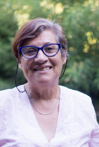 Older woman with glasses smiling at camera