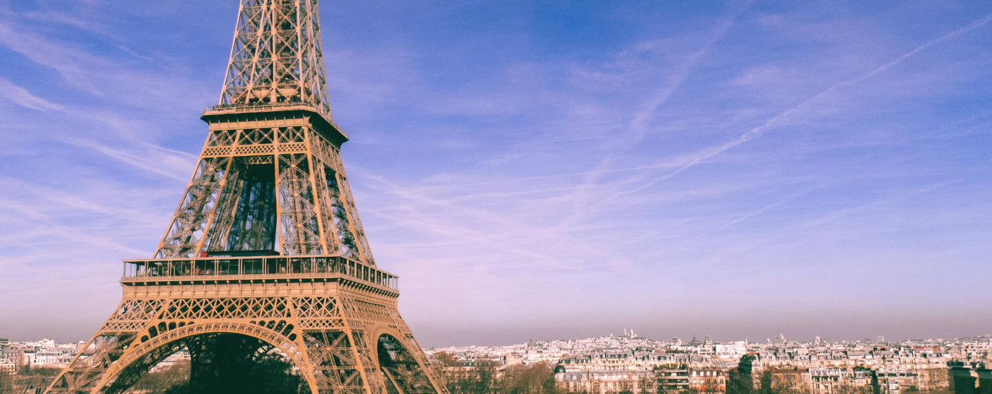 The Eiffel Tower rises above the Paris skyline on a clear day, symbolising French culture, language, and global influence.