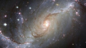 A detailed image of a spiral galaxy in deep space, showing stars, cosmic dust, and glowing light—representing the study of astrophysics and the universe.