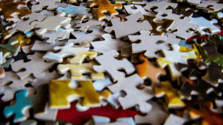 Close-up of colourful jigsaw puzzle pieces scattered on a surface, symbolising the complexity and interconnection of the human mind in psychology.