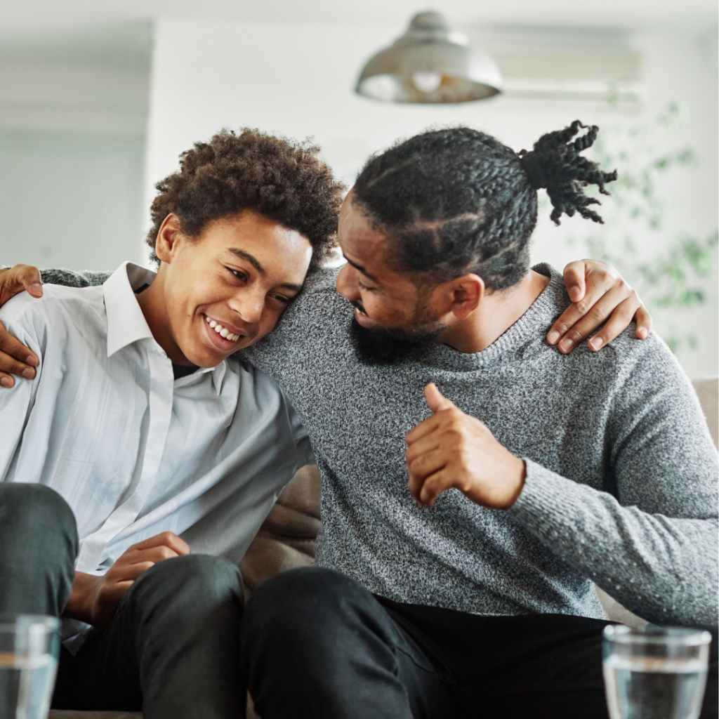 Father supporting his son with a smile and a thumbs-up
