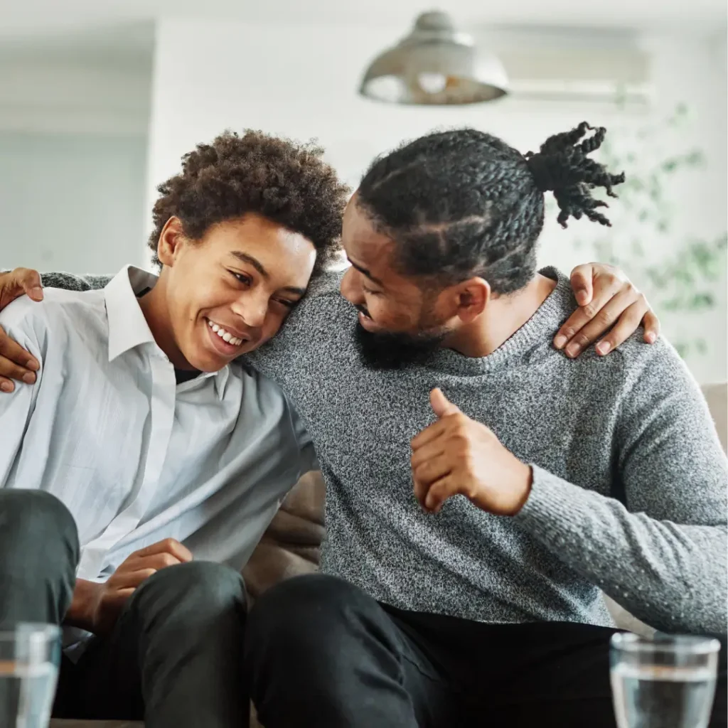 Father supporting his son with a smile and a thumbs-up