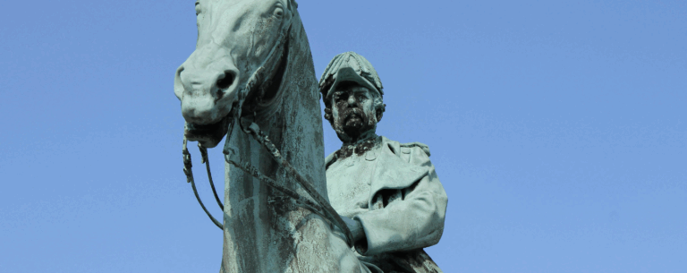 A close-up of a bronze statue of a military figure on horseback, symbolising historical legacy, power, and leadership.