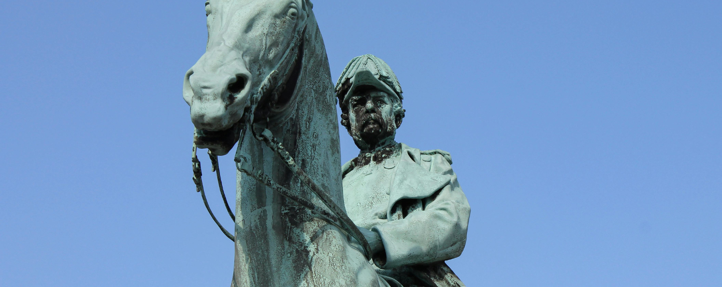 A close-up of a bronze statue of a military figure on horseback, symbolising historical legacy, power, and leadership.