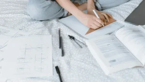 AS level Maths student studying at home on her bed