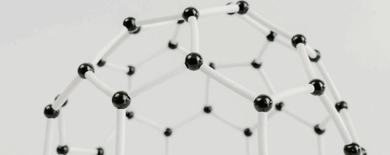 A molecular model showing connected black and white spheres, representing atomic structure and the scientific principles of physics.