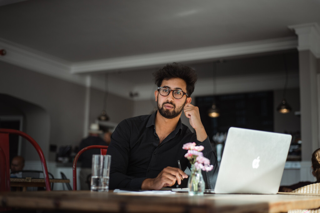 Male NEC worker at desk with laptop