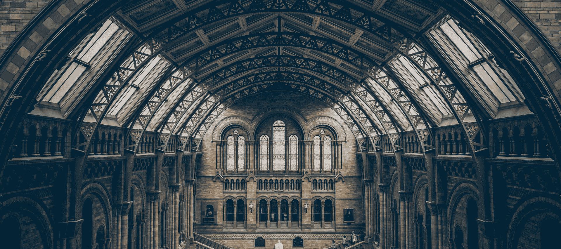 Interior view of a grand historical building with arched architecture and stained-glass windows, representing the study of history and heritage.