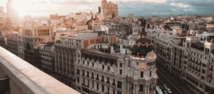 A panoramic view of central Madrid at sunset, featuring the Metropolis building, symbolising Spanish language and culture.