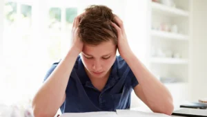 stressed teenager with head in hands after looking at A level results