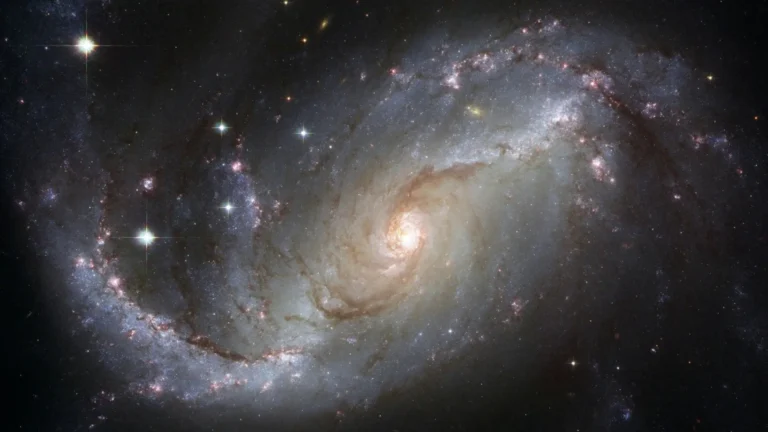 A detailed image of a spiral galaxy in deep space, showing stars, cosmic dust, and glowing light—representing the study of astrophysics and the universe.