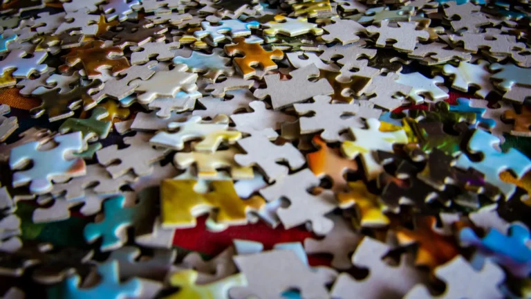 Close-up of colourful jigsaw puzzle pieces scattered on a surface, symbolising the complexity and interconnection of the human mind in psychology.