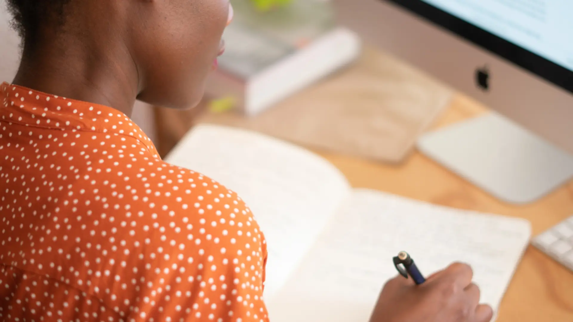 Woman sat at a desk studying for her Structured English Language GCSE with the NEC
