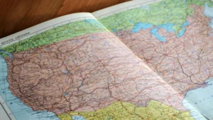A detailed map of the United States with Russian labels, spread open on a wooden table—symbolising global awareness, spatial understanding, and geographical exploration.
