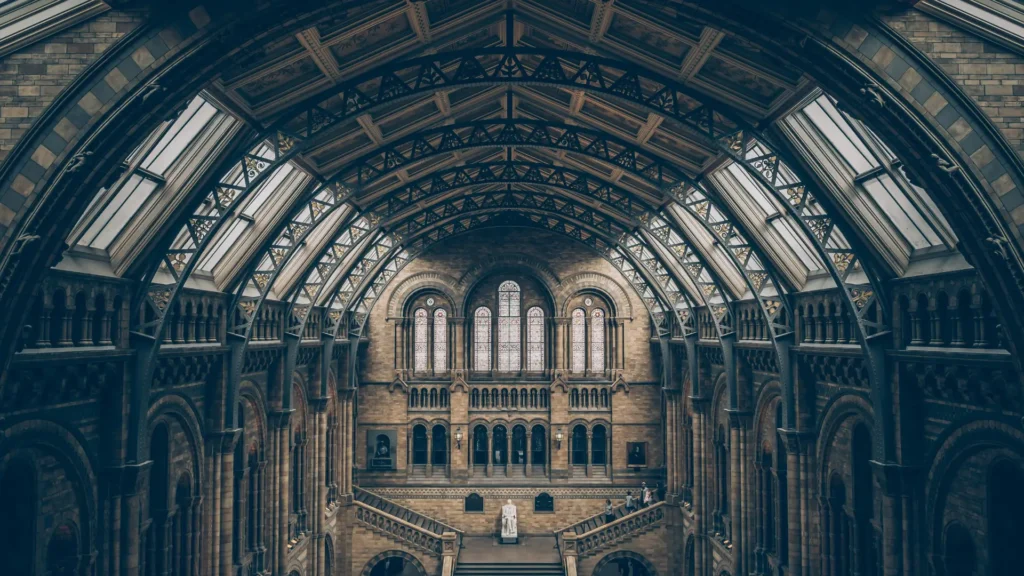 Interior view of a grand historical building with arched architecture and stained-glass windows, representing the study of history and heritage.