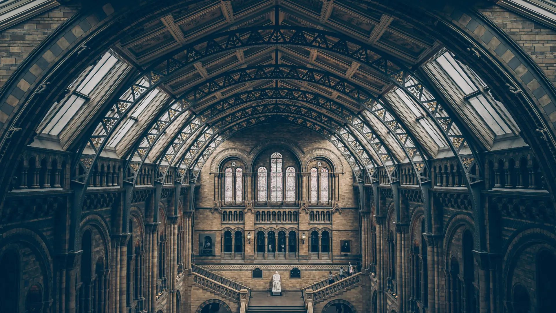 Interior view of a grand historical building with arched architecture and stained-glass windows, representing the study of history and heritage.