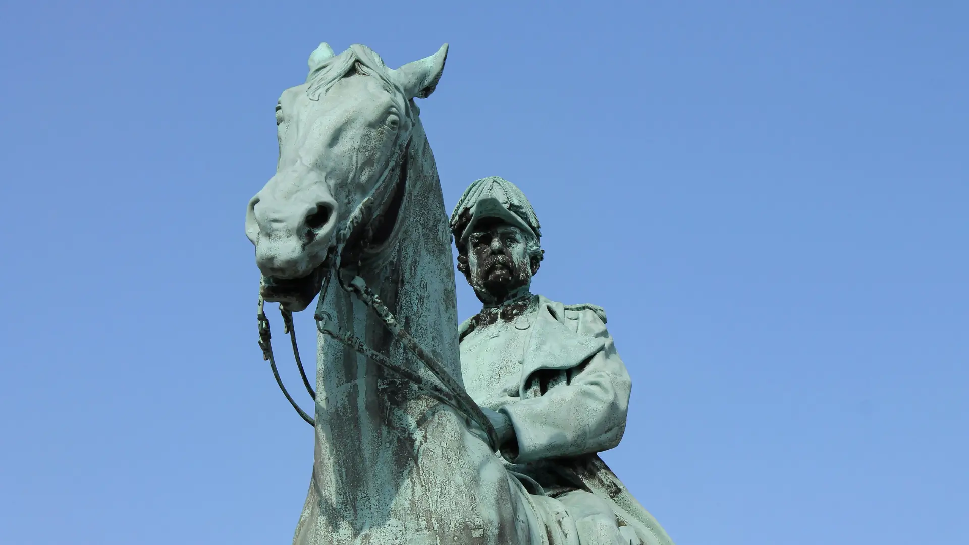 A close-up of a bronze statue of a military figure on horseback, symbolising historical legacy, power, and leadership.