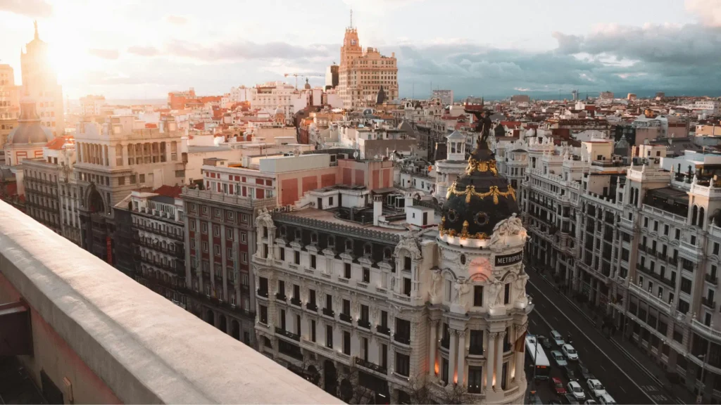 A panoramic view of central Madrid at sunset, featuring the Metropolis building, symbolising Spanish language and culture.