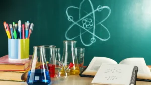 Chemistry aparatus sits on a desk with notes from the student alongside