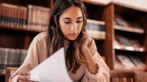 Teenage girl sits in a library studying History