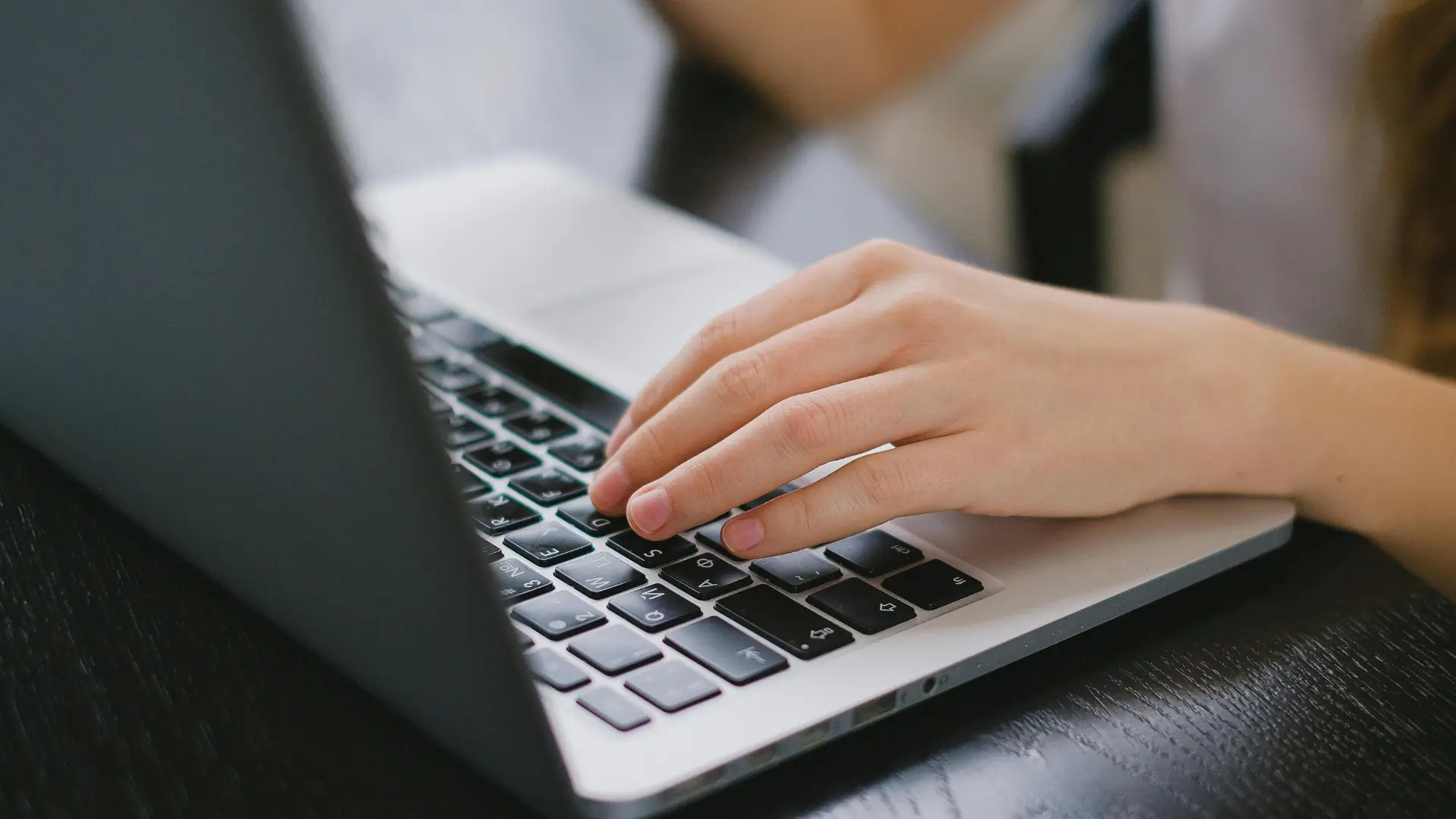 Student typing on a laptop while studying online through distance learning