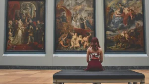 young female sitting in gallery looking at art history