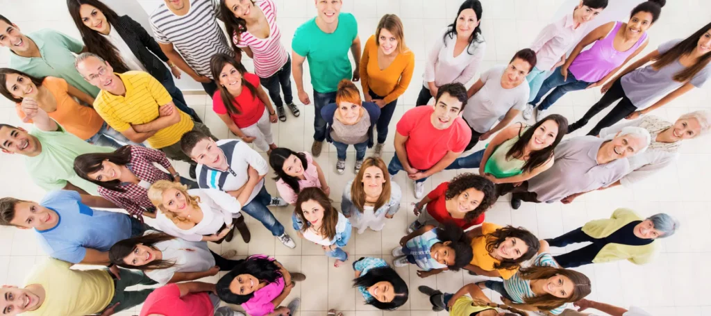 Group of people of all ages looking up at the camera