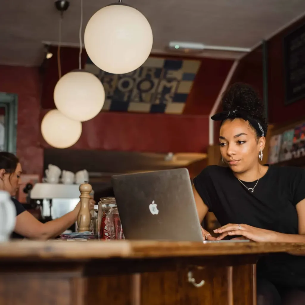 Young woman in a cafe sitting looking at her laptop