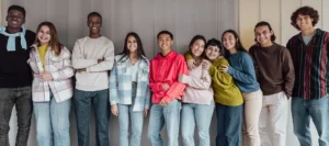 A line of smiling teenage students in colouful clothing