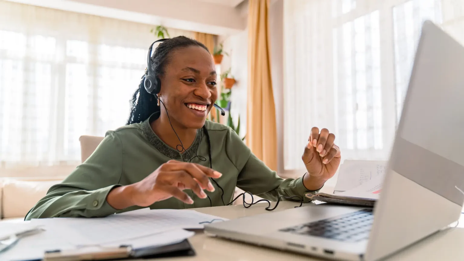 Female working at a desk on a laptop on a video call with NEC pastoral care