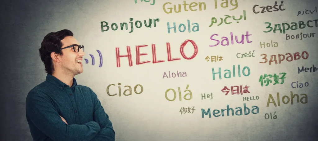 Teacher looking at a whiteboard of 'hello' messages in different languages